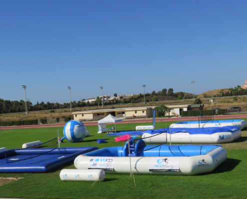 5 piscinas deportivas profesionales WSP® en un campo de atletismo un balon gigante de watervolley y una carpa